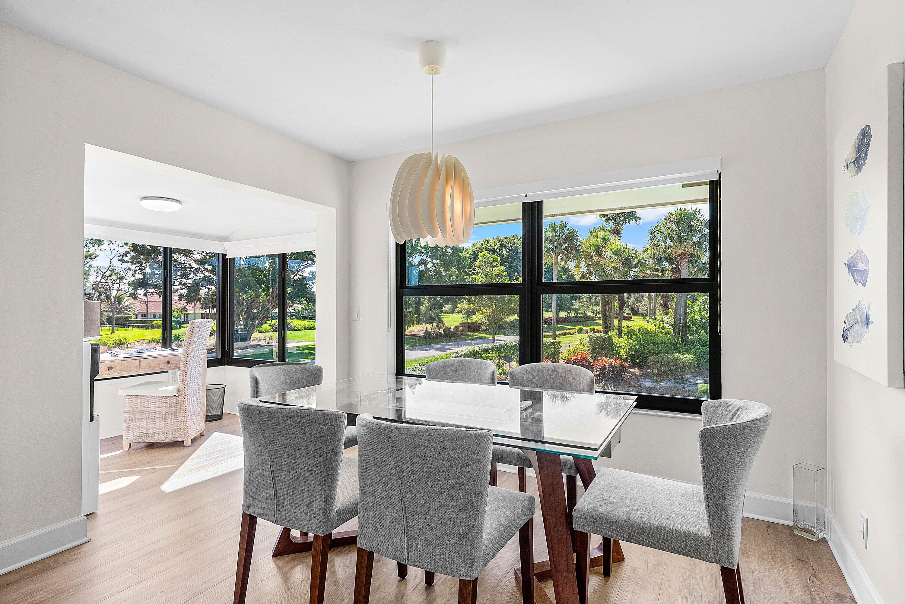10301 Quail Covey Road, Unit HIBISCUS S Boynton Beach, FL 33436 - Photo 7 of 55 a dining room with furniture a chandelier and wooden floor
