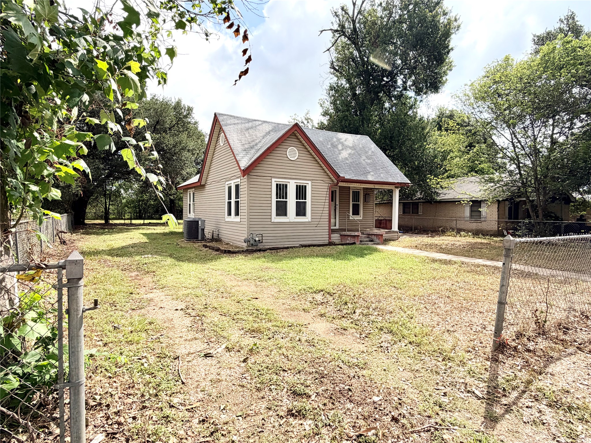 702 East 18th Street Cameron, TX 76520 - Photo 2 of 14 A charming cottage with a welcoming front porch set on a generous, fenced yard awaits.