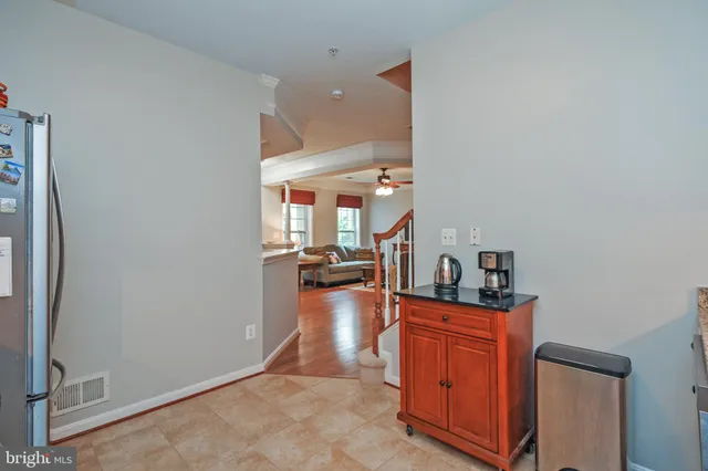 a hallway with a view of living room with wooden floor