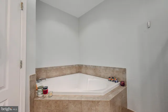 a bathroom with a tub sink and mirror