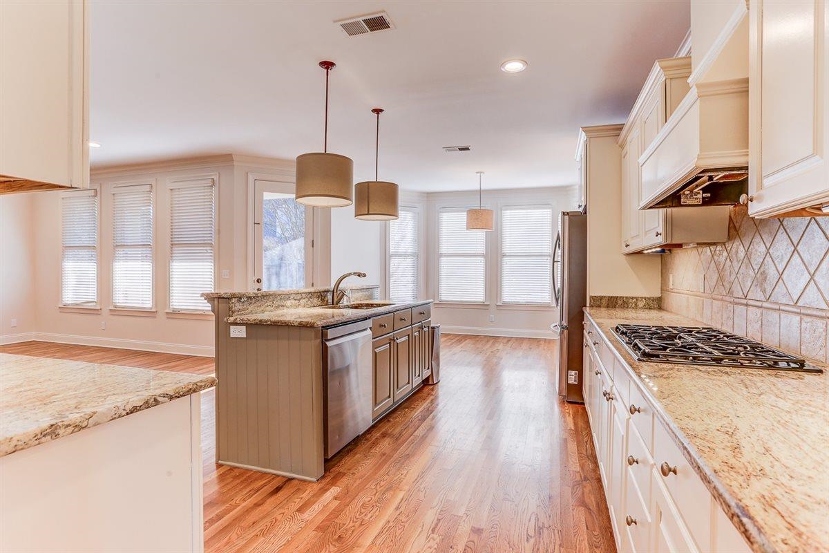 10219 Statfield Drive Collierville, TN 38017 - Photo 8 of 37 a kitchen with stainless steel appliances granite countertop a stove a sink dishwasher a refrigerator and white cabinets with wooden floor