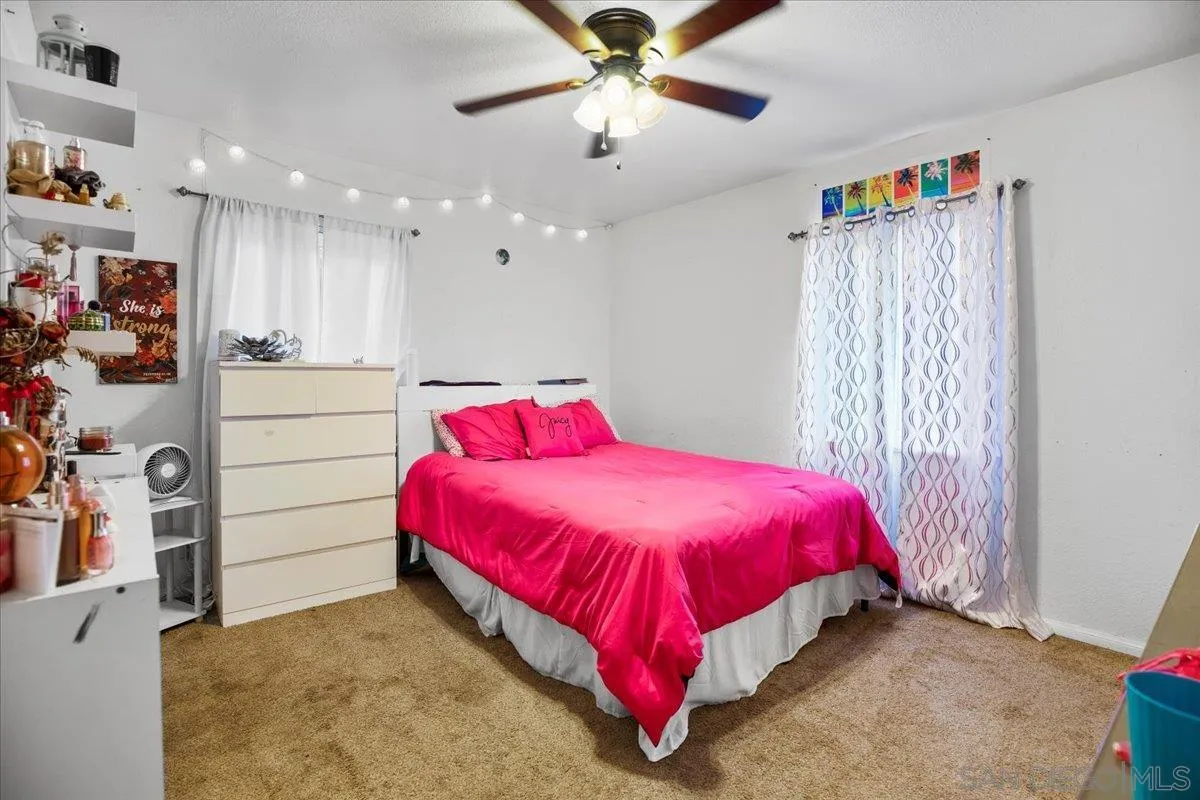 8719 Gardena Road Lakeside, CA 92040 - Photo 15 of 38 a bed room with a bed and a chandelier
