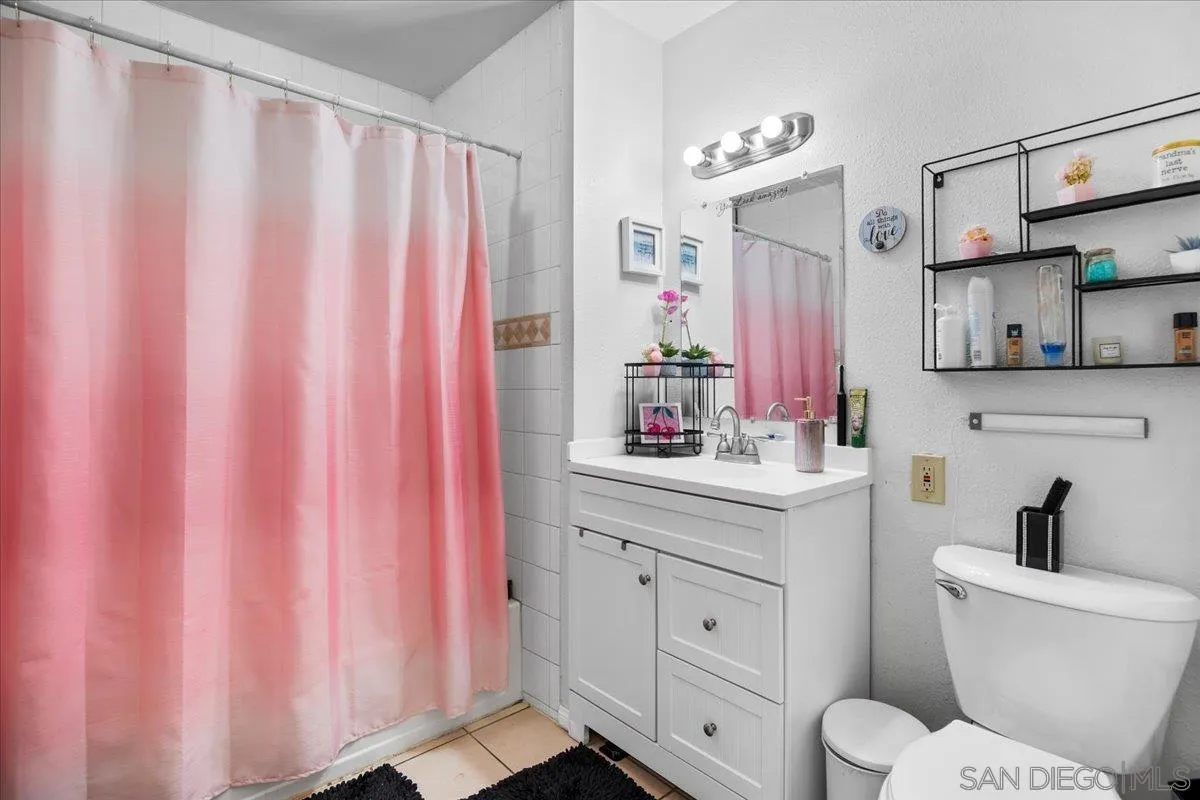 8719 Gardena Road Lakeside, CA 92040 - Photo 19 of 38 a bathroom with a sink a toilet and shower curtain