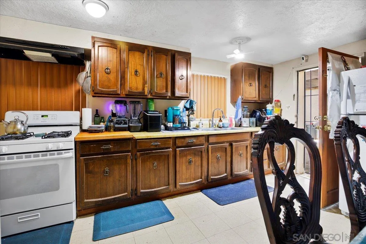 8719 Gardena Road Lakeside, CA 92040 - Photo 28 of 38 a kitchen with stainless steel appliances sink stove and cabinets