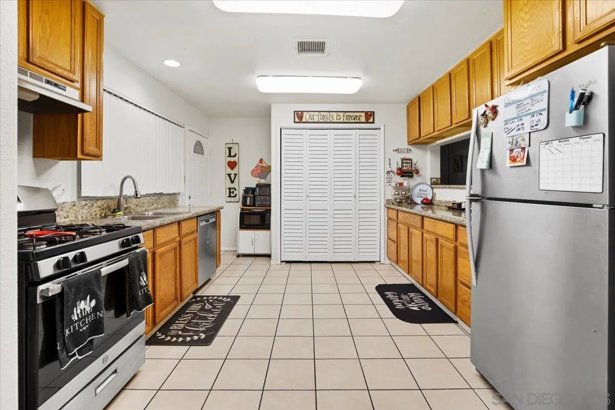 8719 Gardena Road Lakeside, CA 92040 - Photo 7 of 38 a kitchen with a stove a refrigerator and cabinets