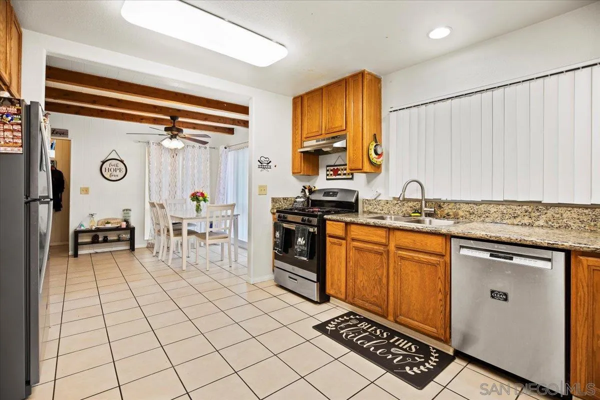 8719 Gardena Road Lakeside, CA 92040 - Photo 10 of 38 a kitchen with stainless steel appliances granite countertop a stove a sink and a microwave