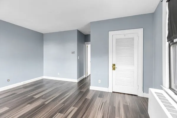 a view of an empty room with closet and a window