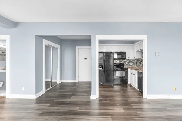 a view of a kitchen with a refrigerator and a stove top oven