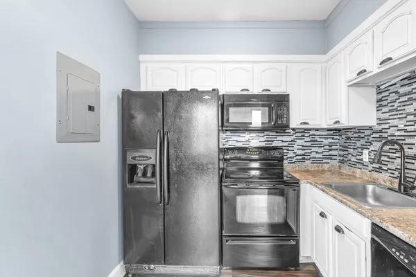 a kitchen with stainless steel appliances granite countertop a refrigerator and a stove