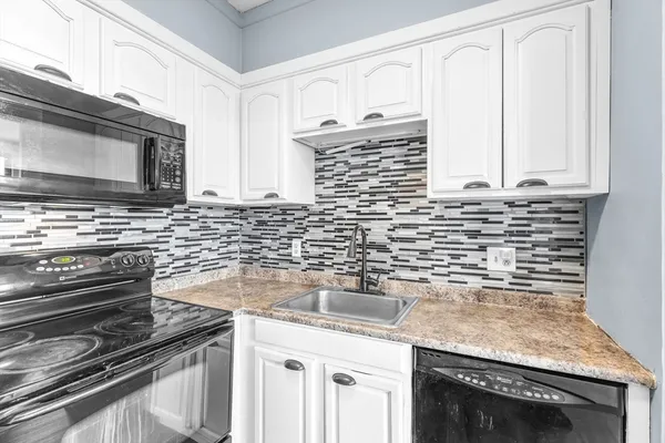 a kitchen with granite countertop a sink stove and cabinets