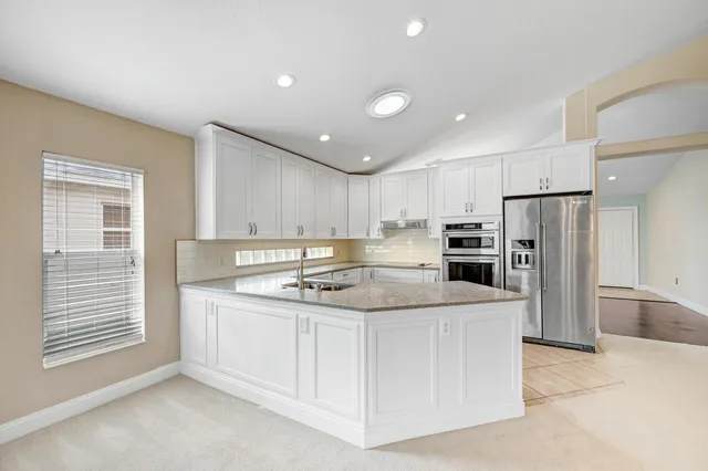 a kitchen with stainless steel appliances granite countertop a sink stove and refrigerator