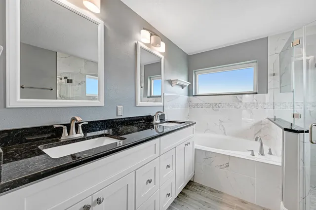 a bathroom with a granite countertop sink a large mirror a shower and