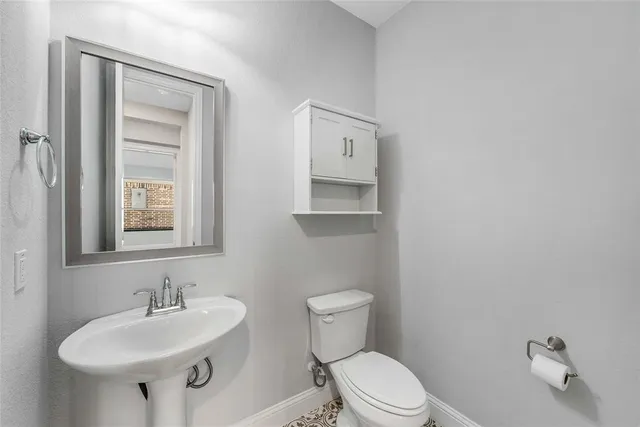 a bathroom with a sink a toilet and mirror