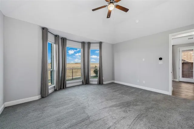 an empty room with fan and windows