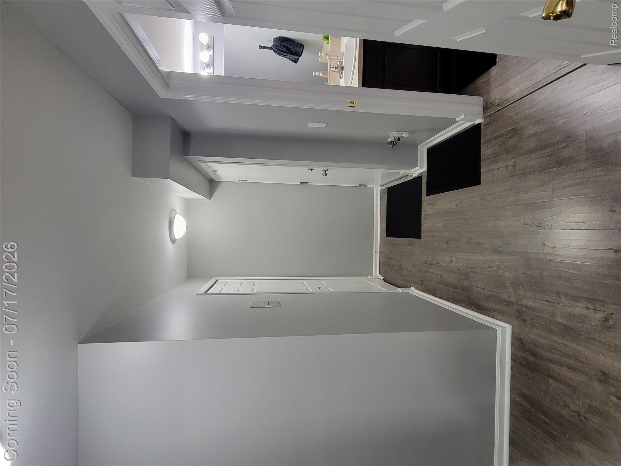 1655 Riverside Drive, Unit 10 Rochester, MI 48309 - Photo 41 of 44 Hallway featuring wood-finish flooring, light gray walls, and white trim