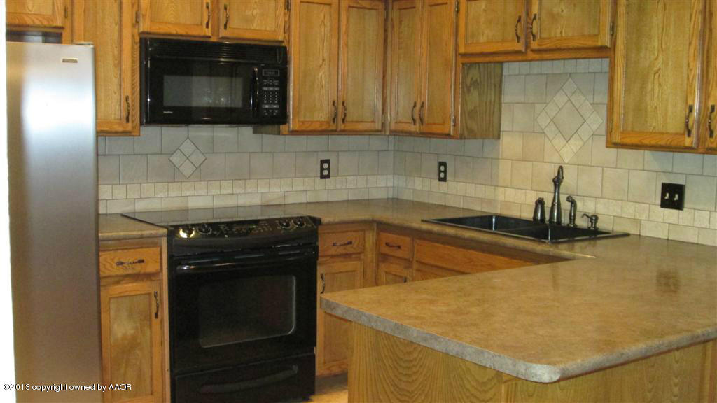 4211 Relatta Avenue Amarillo, TX 79110 - Photo 6 of 41 a kitchen with stainless steel appliances granite countertop a sink a stove and microwave