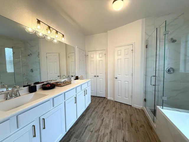 a bathroom with a sink a large mirror and shower