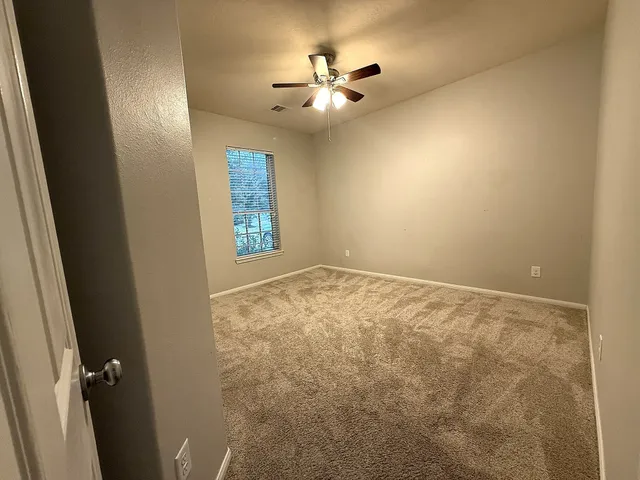 en view of an empty room and chandelier fan