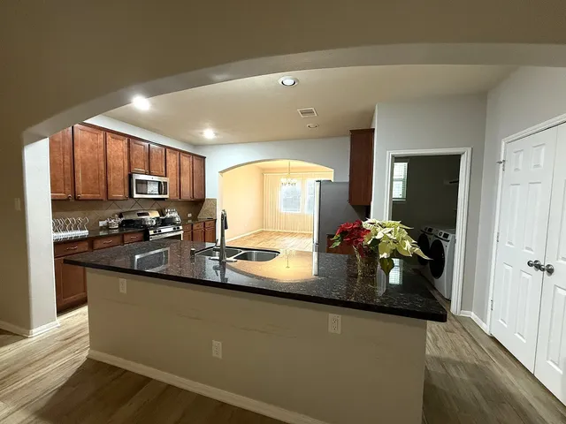 a kitchen with sink a refrigerator and a wooden cabinets