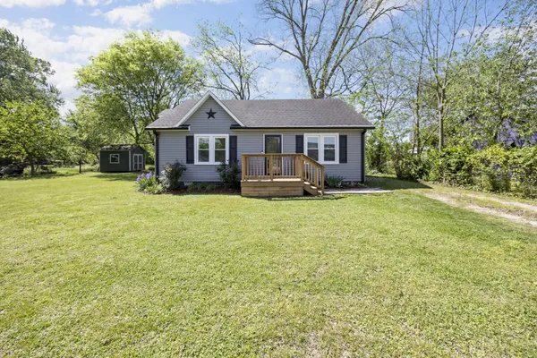 a front view of a house with yard and trees
