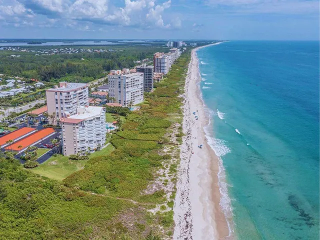 a blue and white building with a yard and lake view