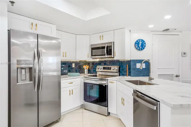 a kitchen with stainless steel appliances granite countertop a table and chairs in it