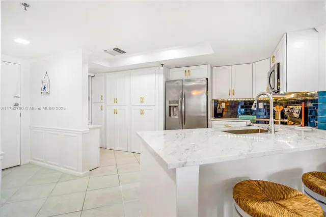 a kitchen with granite countertop a refrigerator sink and microwave