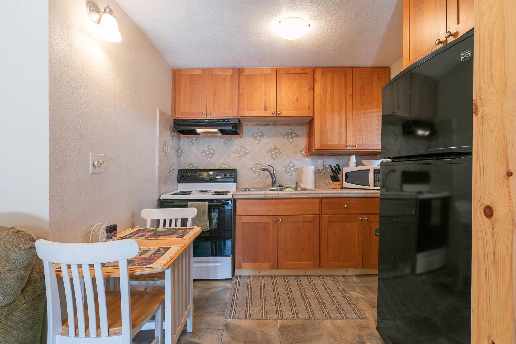 13746 Mogul Way Truckee, CA 96161 - Photo 6 of 21 a kitchen with stainless steel appliances granite countertop a stove a sink a microwave and a refrigerator
