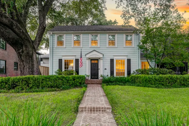 a front view of a house with yard and green space