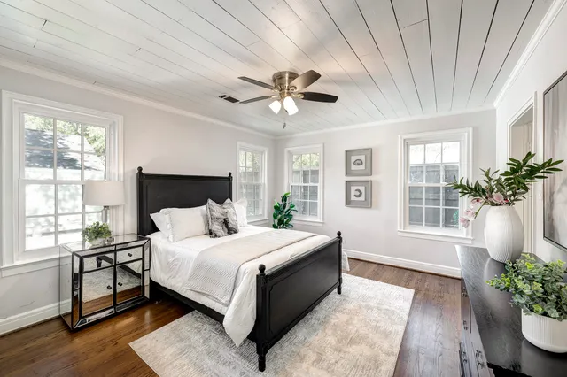 a bedroom with a large bed and a potted plant