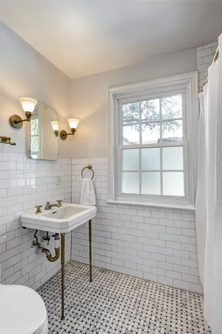 a bathroom with a sink a toilet and a mirror