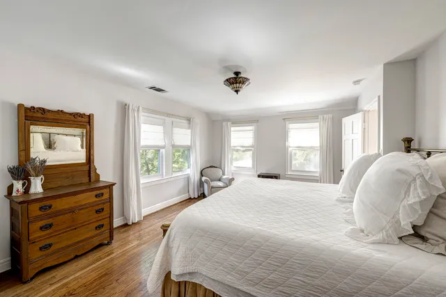 a spacious bedroom with a bed and wooden floor