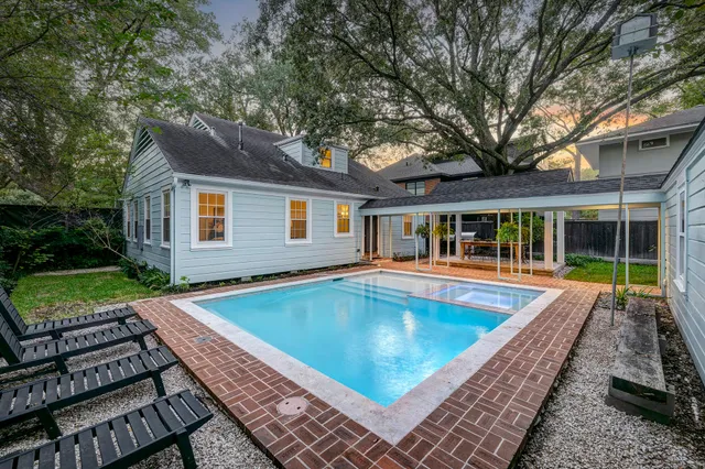 a view of a house with pool fire pit couches and chairs