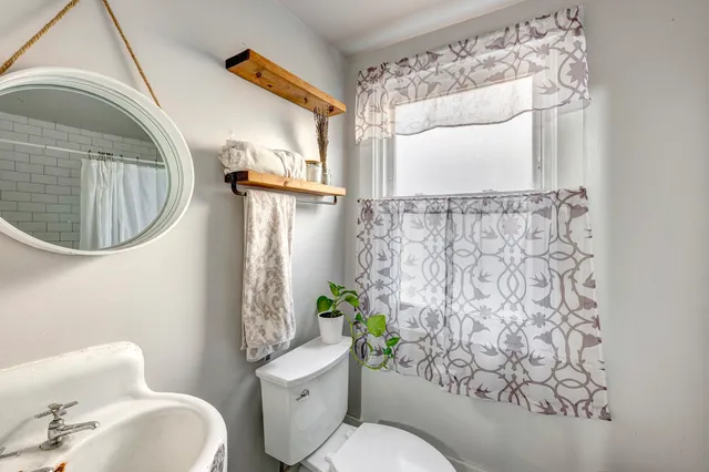 a bathroom with a toilet sink and mirror