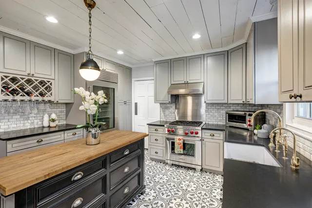 a kitchen with stainless steel appliances a stove a sink cabinets and a refrigerator