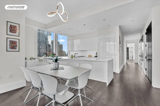 a large white kitchen with a large window and stainless steel appliances