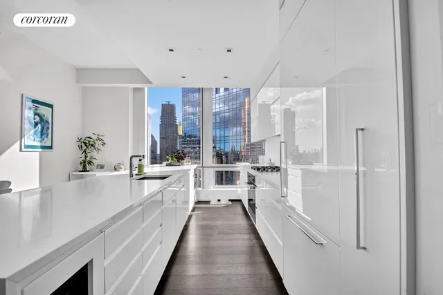 a view of a dining room and livingroom with furniture wooden floor a chandelier