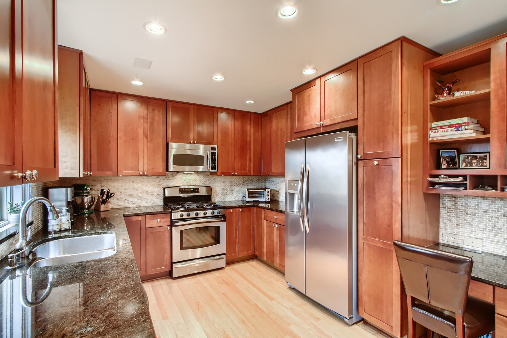 50 Northgate Road Riverside, IL 60546 - Photo 9 of 33 a kitchen with stainless steel appliances granite countertop a refrigerator a stove and a sink with wooden cabinets