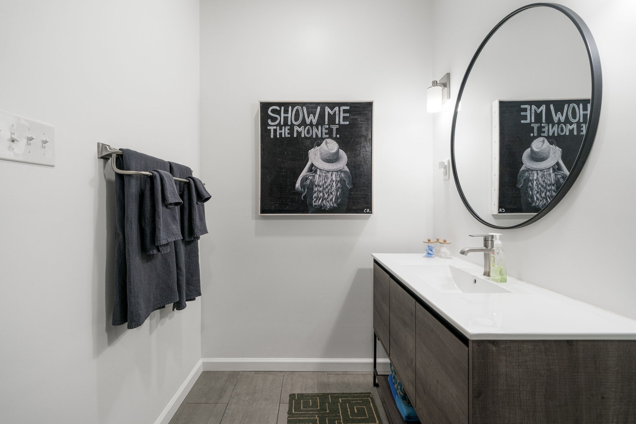 400 Hackberry Street Lockhart, TX 78644 - Photo 27 of 40 A well-appointed lavatory boasts sleek flooring and a contemporary vanity with a contrasting round mirror.