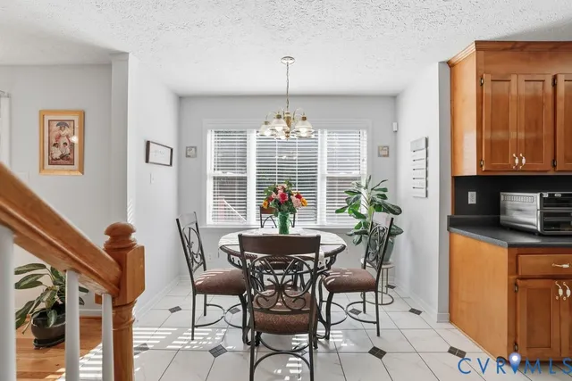 a dining room with furniture a chandelier and window