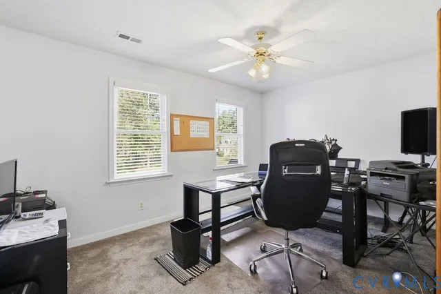 a view of a workspace with furniture and a window
