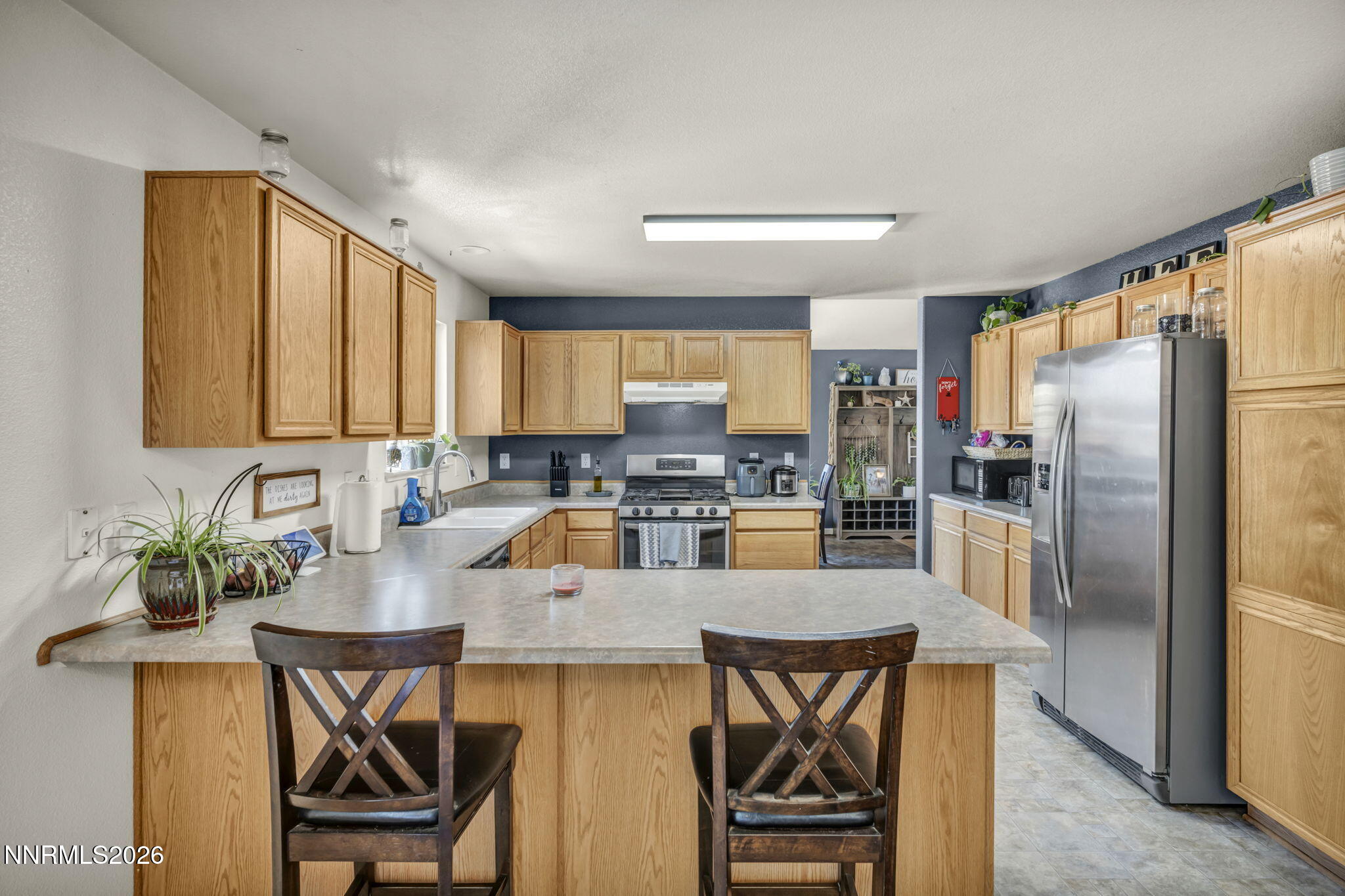 17615 Baileyville Court Reno, NV 89508 - Photo 5 of 19 a kitchen with granite countertop a refrigerator a stove a dining table and chairs