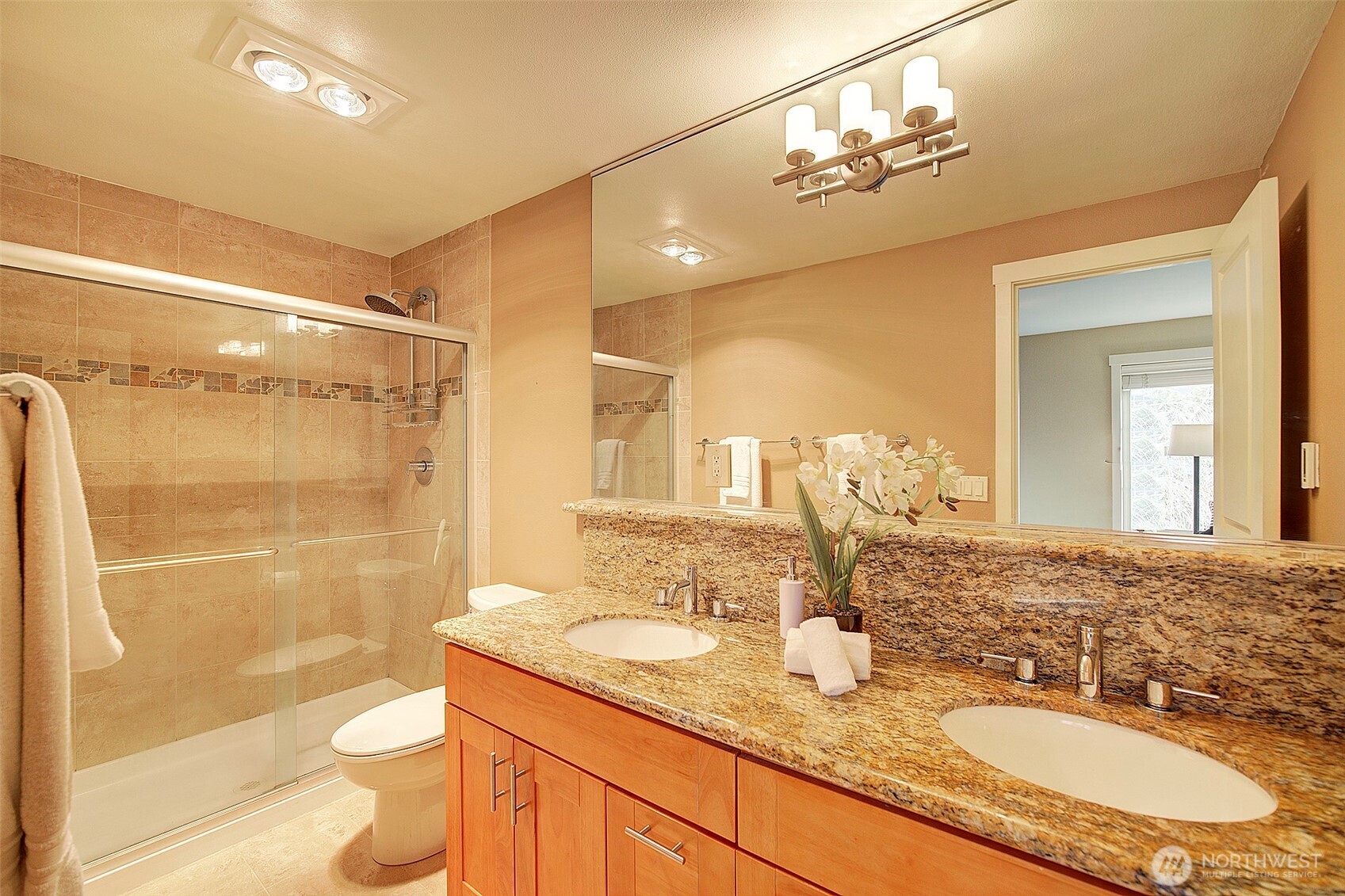 8503 Bowdoin Way, Unit 203 Edmonds, WA 98026 - Photo 13 of 19 a bathroom with a granite countertop sink toilet a mirror a shower and vanity