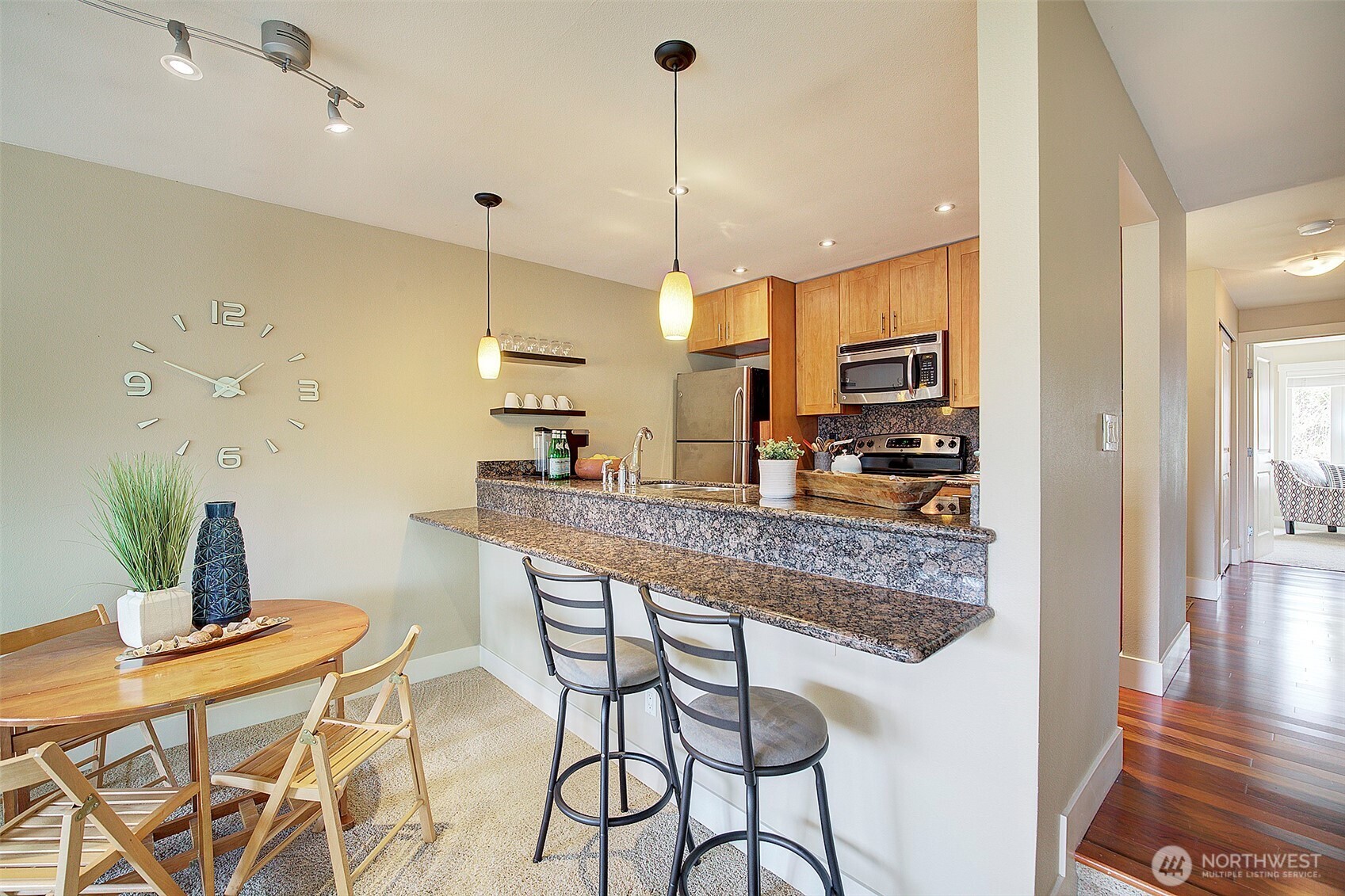 8503 Bowdoin Way, Unit 203 Edmonds, WA 98026 - Photo 8 of 19 a kitchen with stainless steel appliances granite countertop sink stove and white cabinets with wooden floor