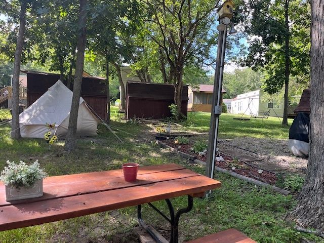 2795 East 28th Road Marseilles, IL 61341 - Photo 11 of 50 a view of a backyard with table and chairs potted plants and large tree