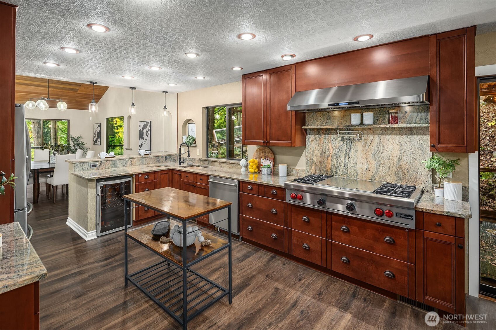 25156 Southeast 158th Street Issaquah, WA 98027 - Photo 9 of 30 a kitchen with stainless steel appliances granite countertop a stove a sink and a dining table