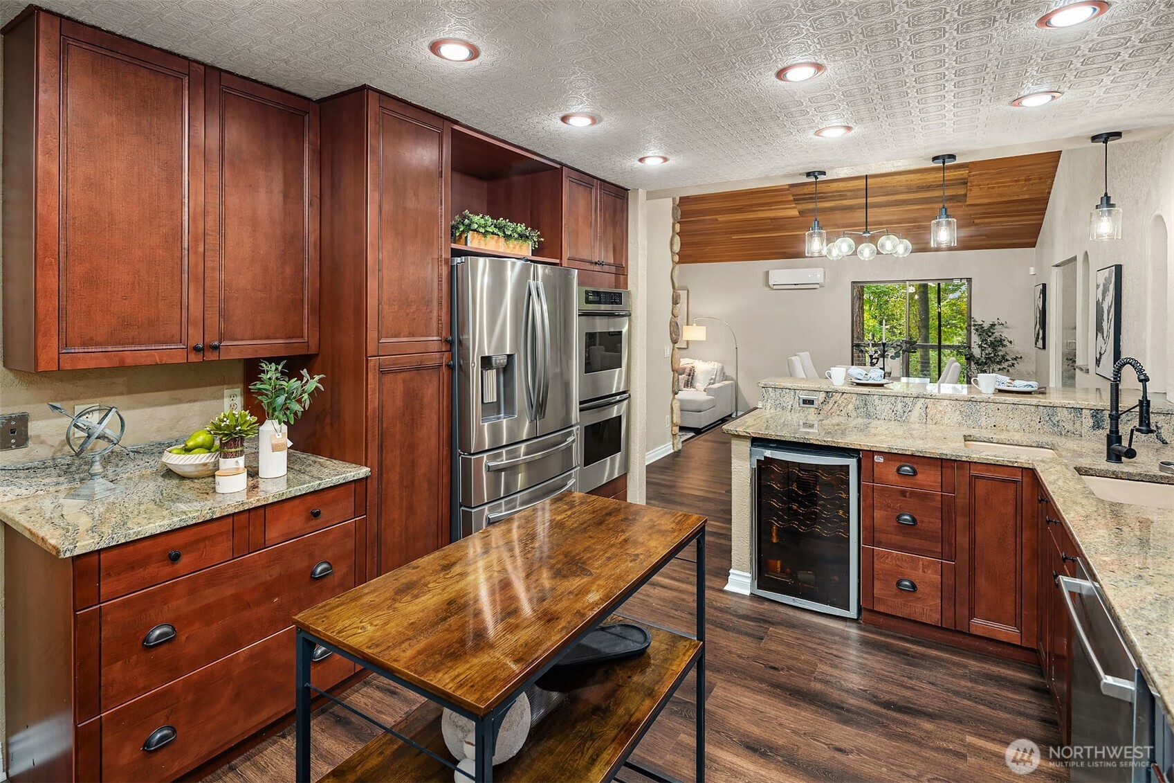 25156 Southeast 158th Street Issaquah, WA 98027 - Photo 10 of 30 a kitchen with stainless steel appliances kitchen island granite countertop a refrigerator and wooden cabinets
