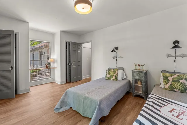 a spacious bedroom with a bed and wooden floor
