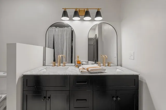 a bathroom with a double vanity sink and a mirror