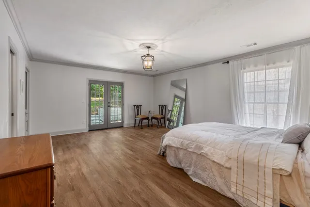 a spacious bedroom with a bed and a table in it with window
